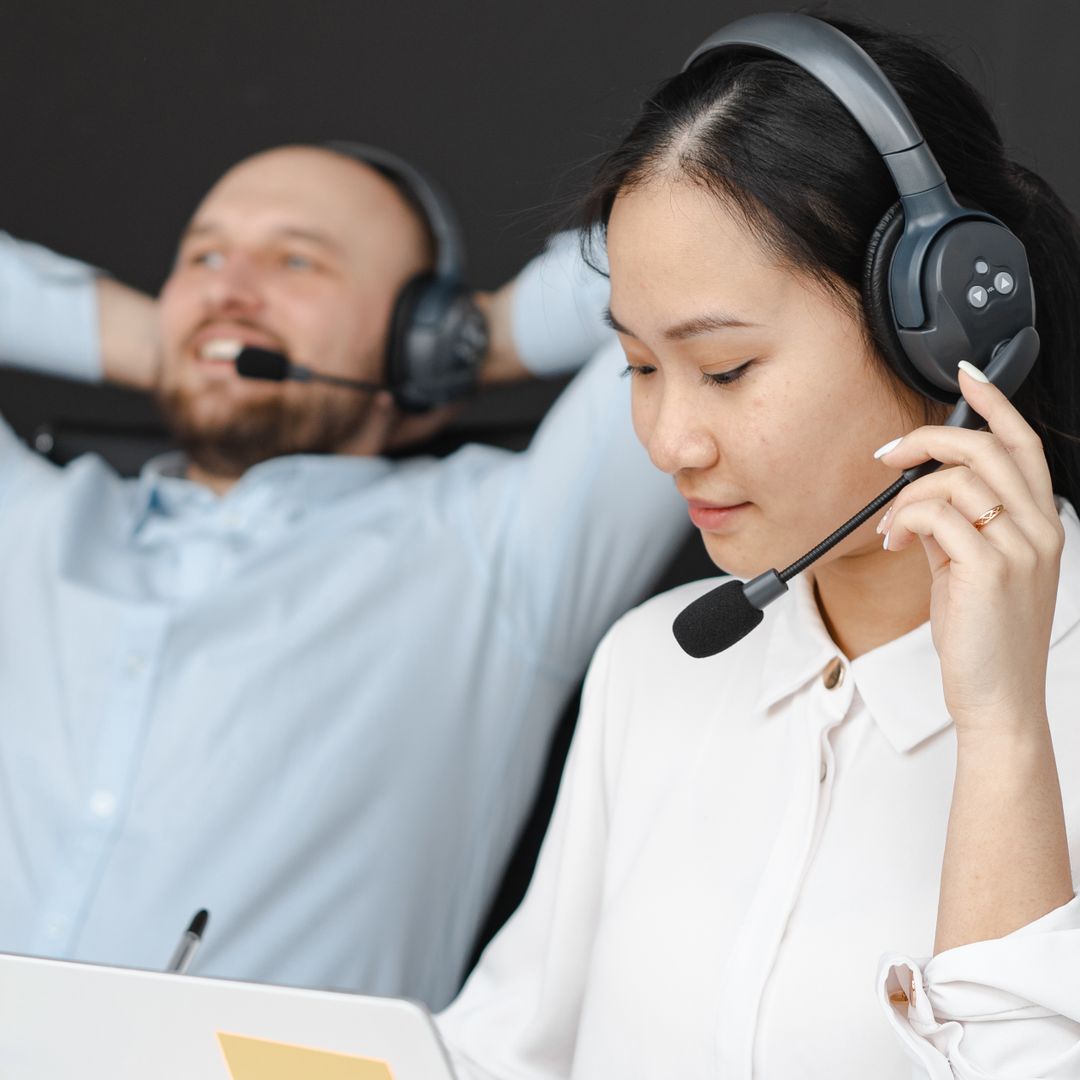 Close-up of customer service representatives wearing headsets in an office