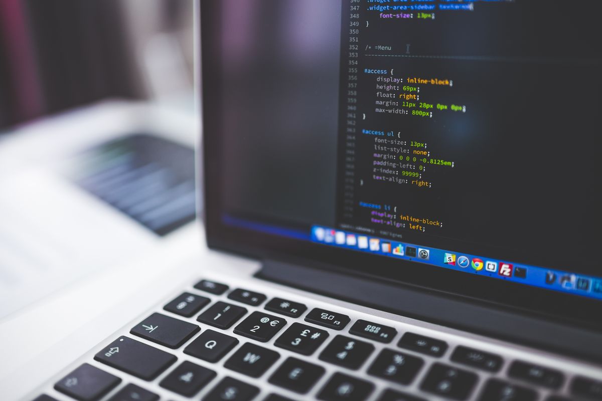 Laptop screen showing HTML code in shallow focus