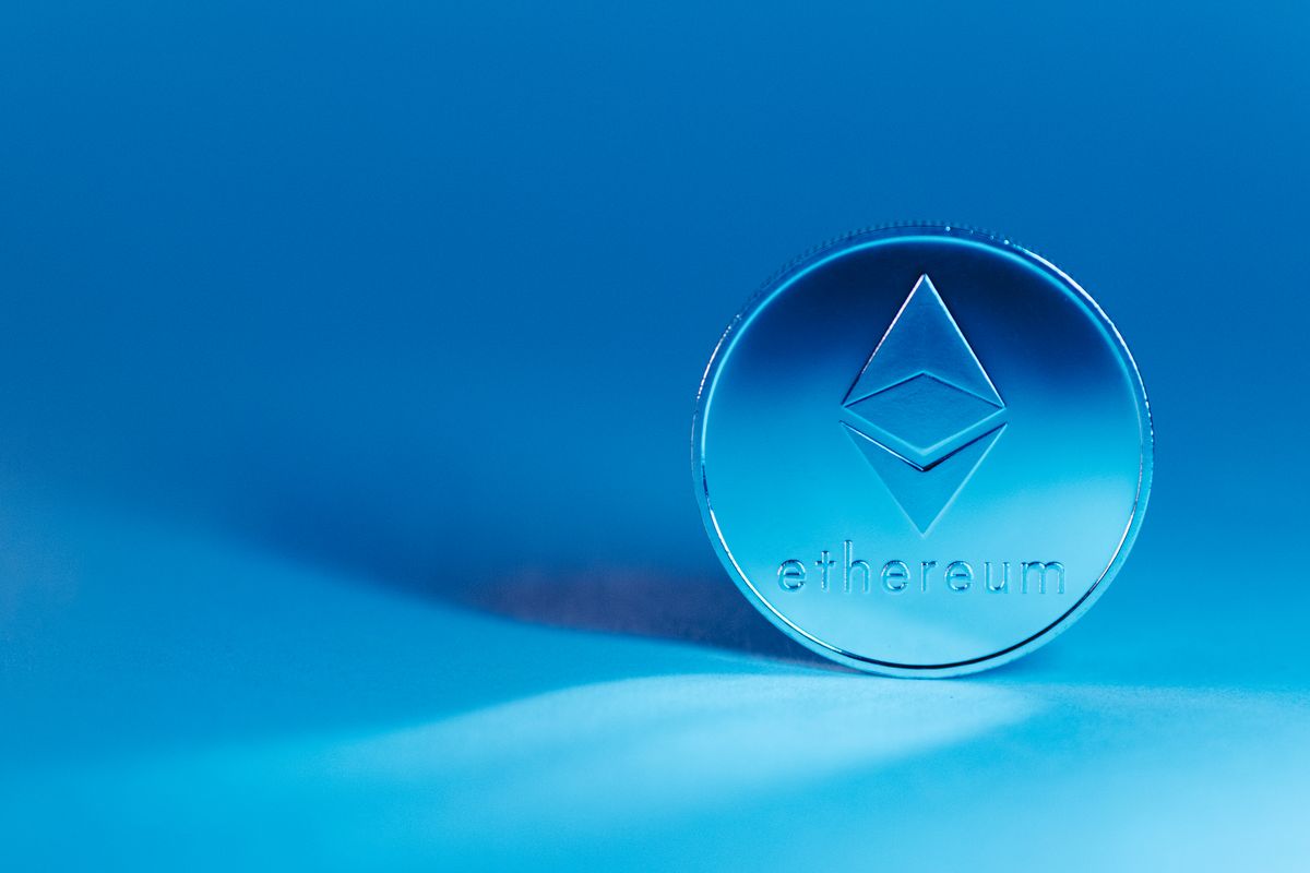 Ethereum coin standing against a blue background