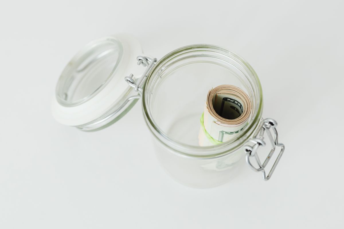 Rolled dollar bills stored in a glass savings jar