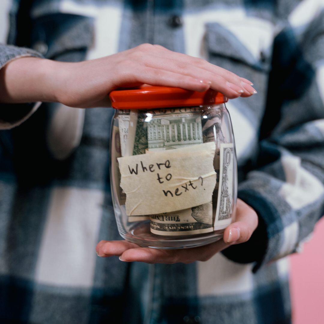 Woman holding a glass jar full of money
