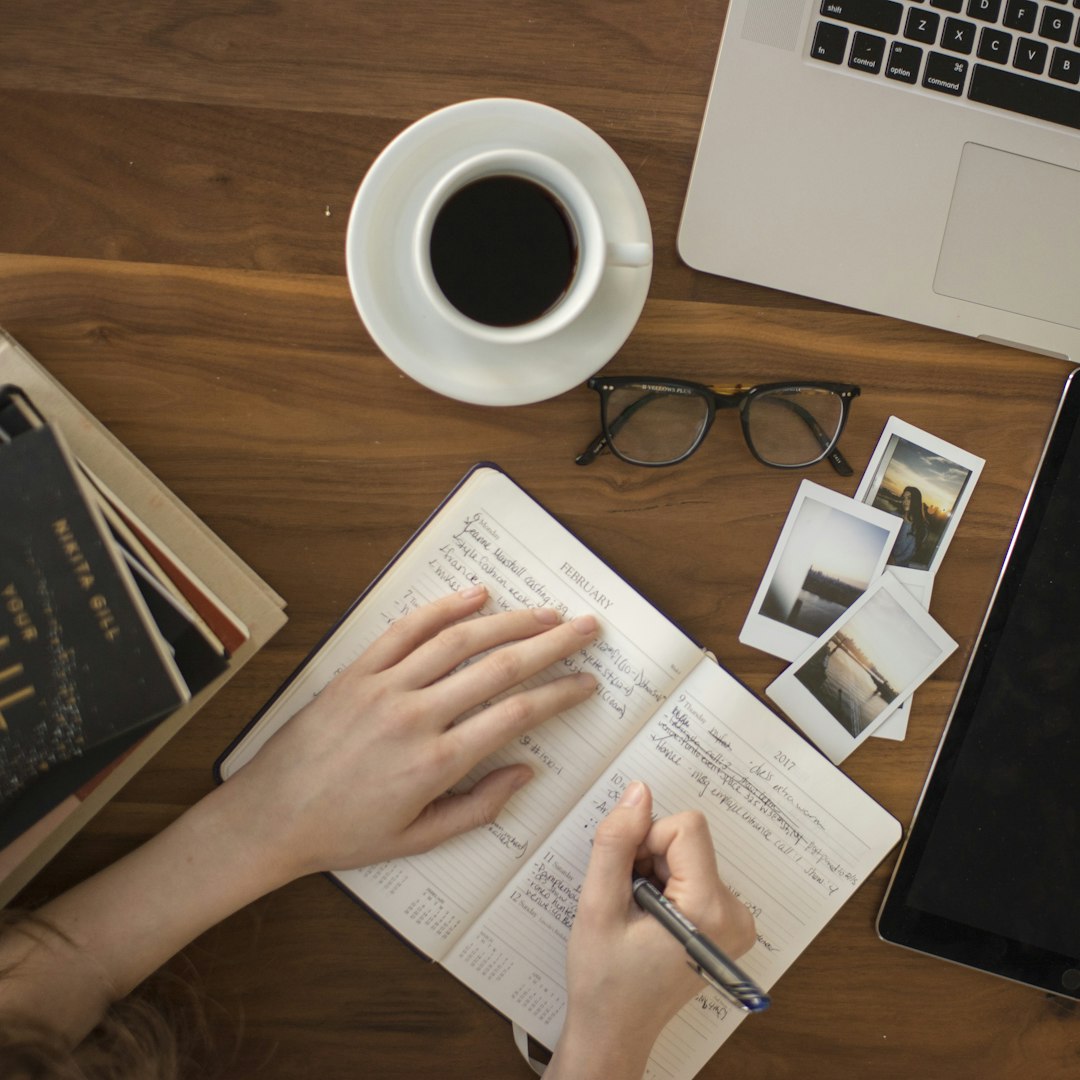 Writing desk with notebook, pen and laptop for freelance work