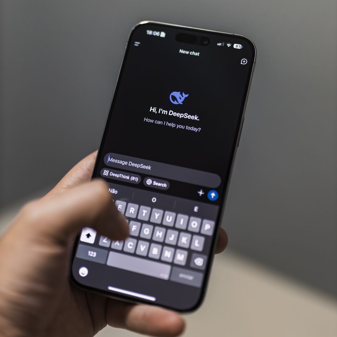 Hand holding a smartphone with an AI assistant app on screen