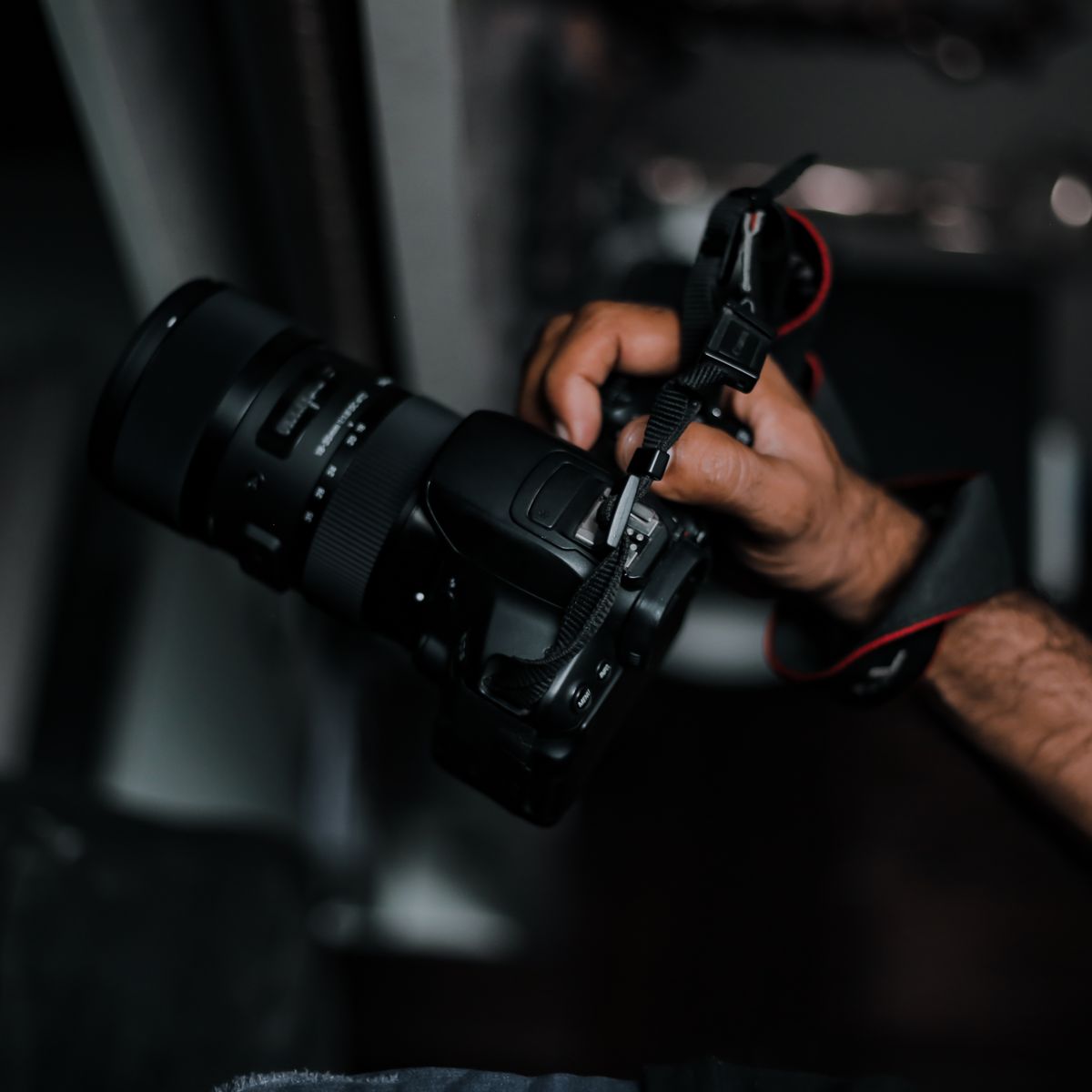 Photographer's hand holding a DSLR camera