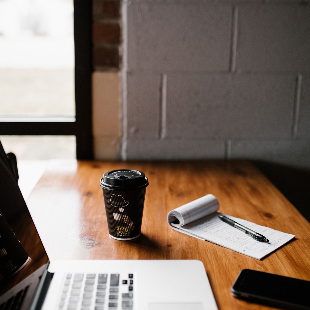 Cozy workspace with a laptop and coffee cup on a desk