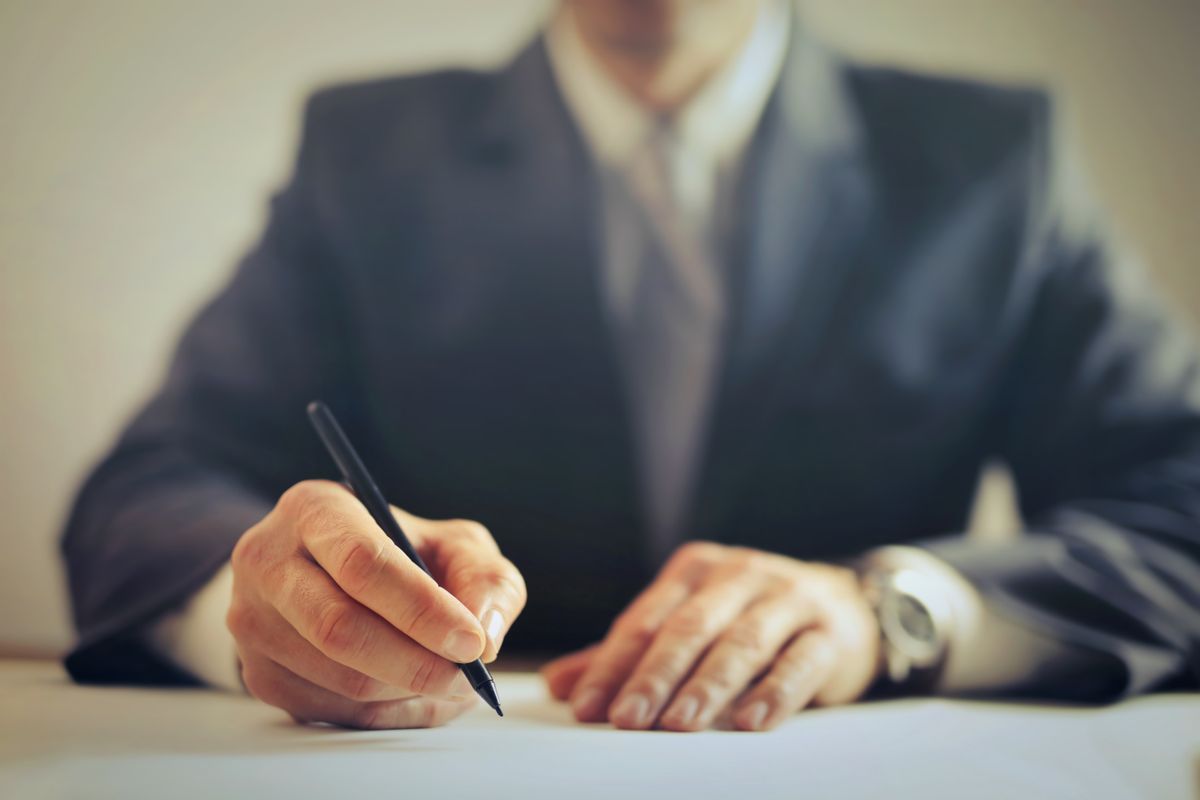A business owner signing loan documents at a desk