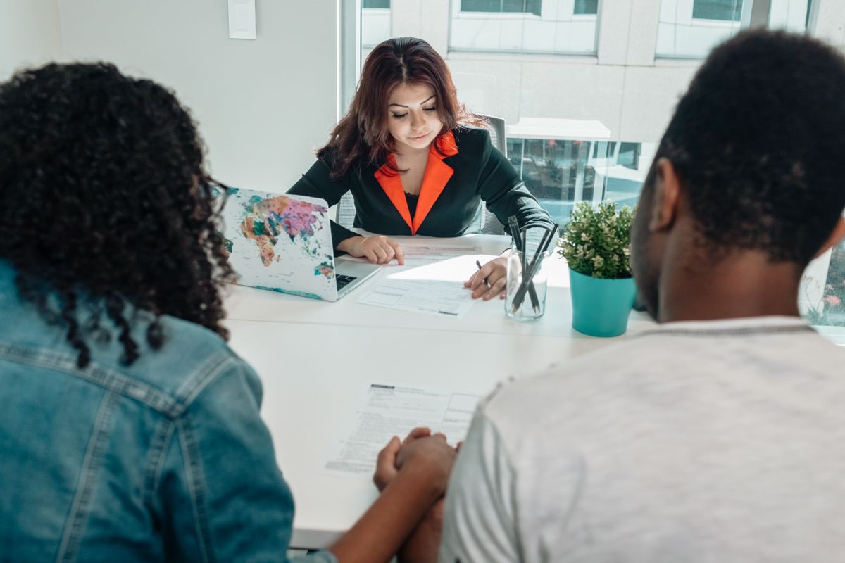 Couple discussing legal documents with an advisor in a modern office