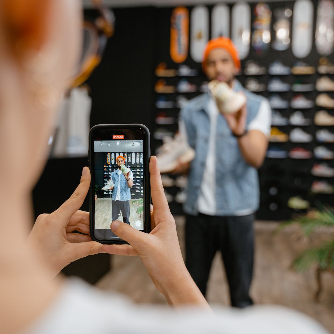 A person filming a product video with a smartphone inside a store