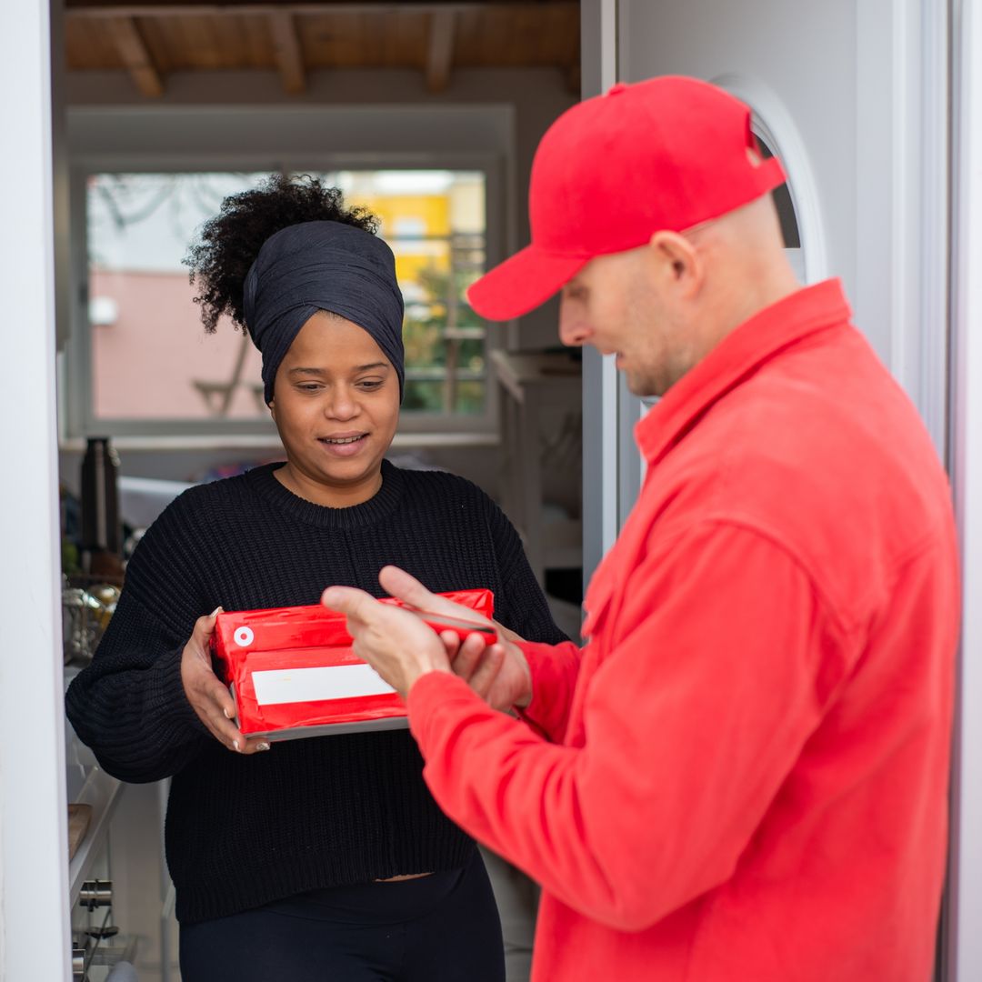 Happy customer receiving a parcel at her door